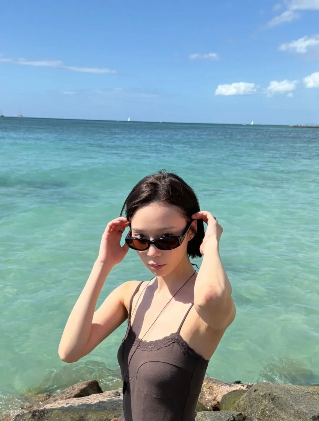 Photo by aespa 에스파 FANPAGE on February 19, 2026. May be an image of sunglasses, ocean, beach, horizon and text.