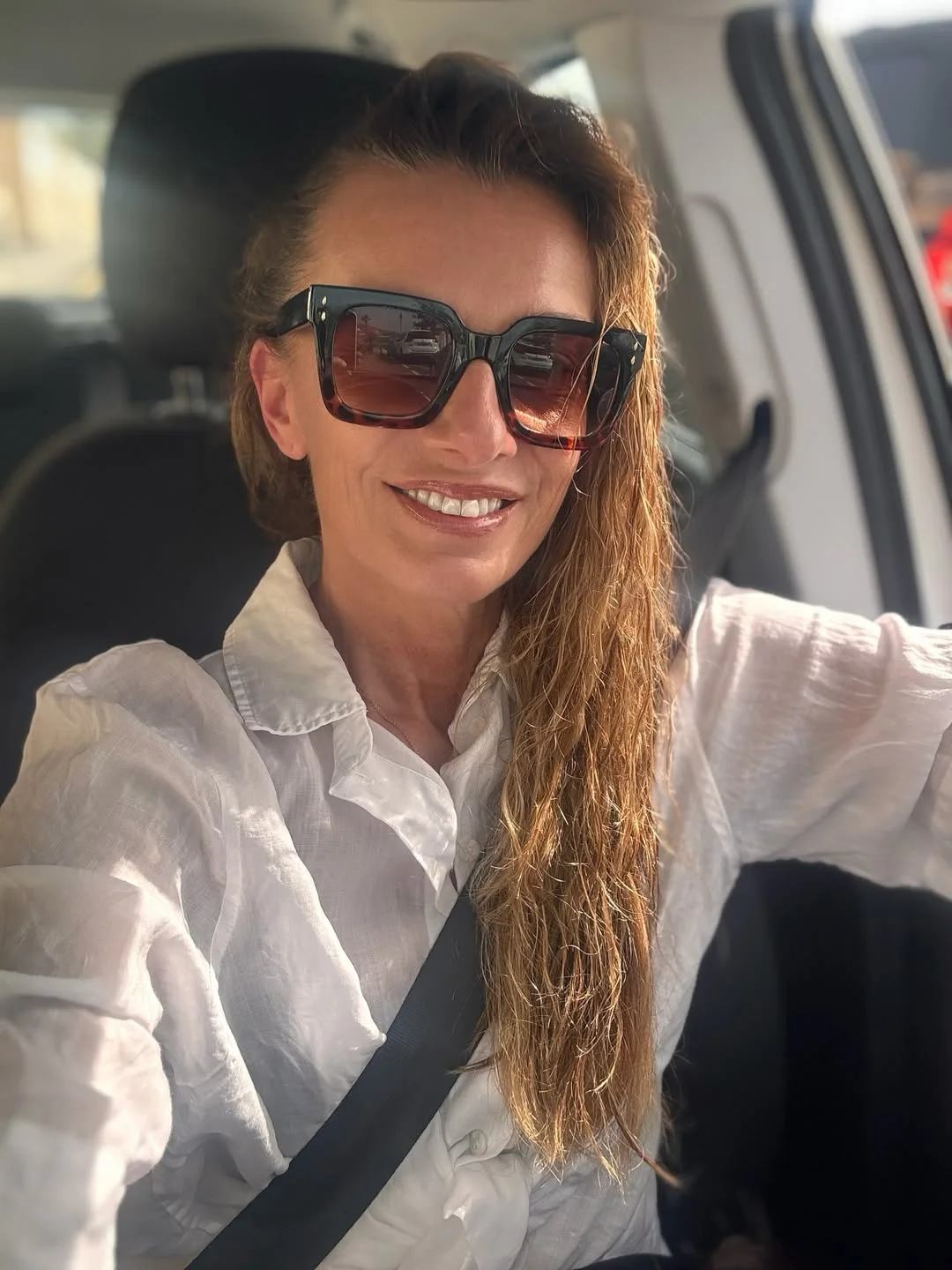 Photo by Alice Bendova on February 19, 2026. May be a selfie of one or more people, blonde hair, people smiling, seatbelt, sunglasses and text.