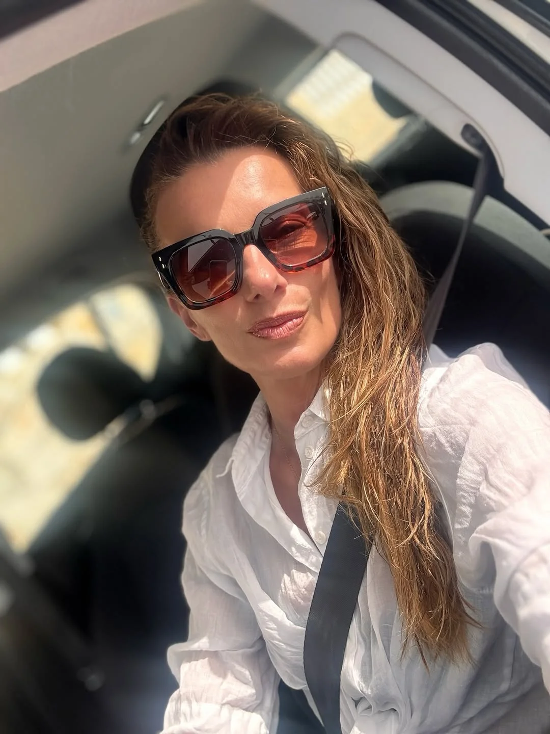 Photo by Alice Bendova on February 19, 2026. May be a selfie of one or more people, people smiling, seatbelt, sunglasses and text.