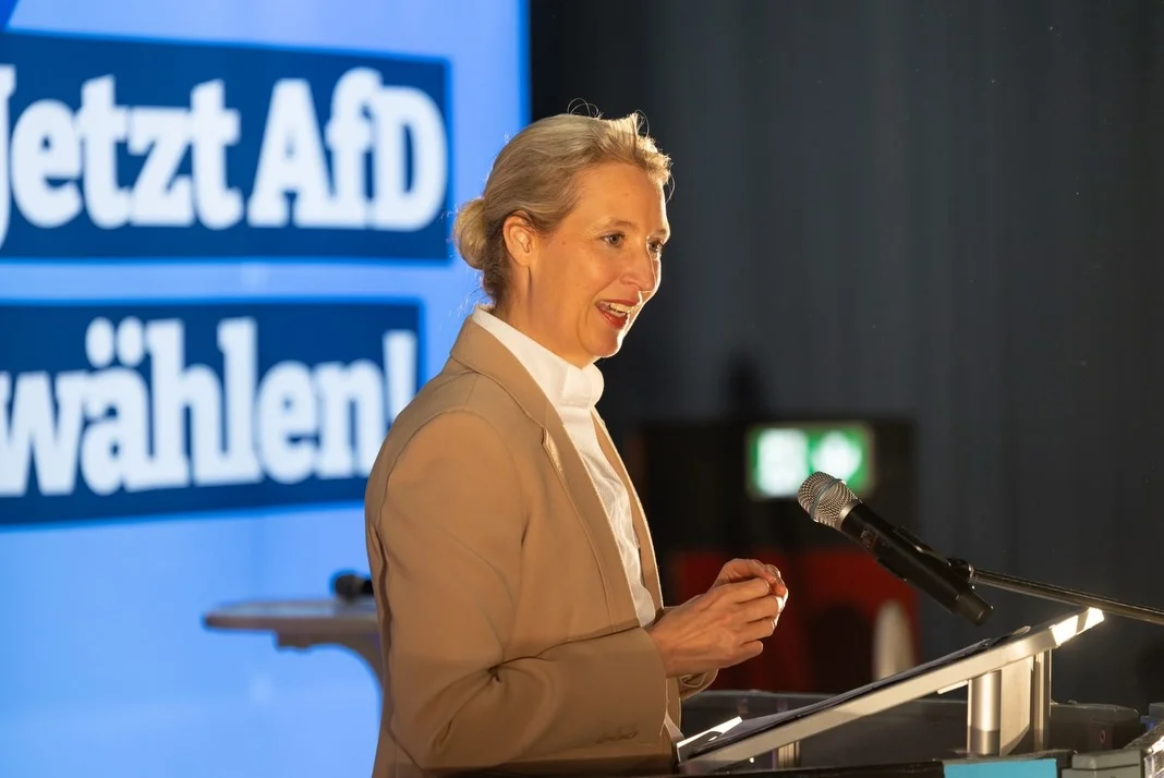 Photo by Alice Weidel on February 21, 2026. May be an image of one or more people, microphone and text that says 'etztAfD wählen n'.