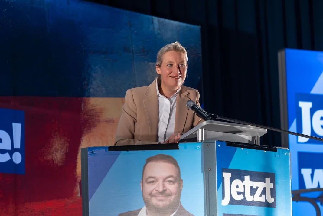 Photo by Alice Weidel on February 21, 2026. May be an image of microphone and text that says '! I Jetzt L V'.